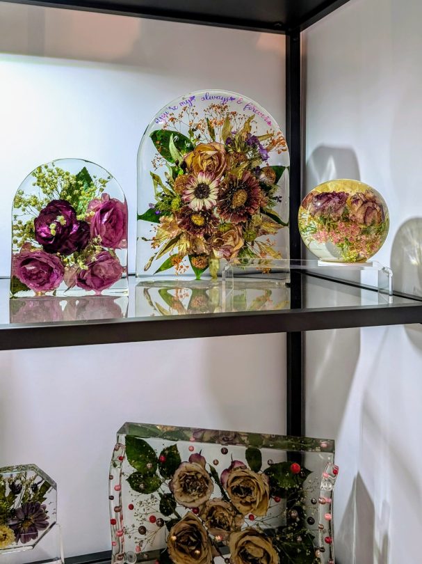 Getrocknete Blumen in klaren Kunststoffen, in verschiedenen Formen und Anordnungen präsentiert.