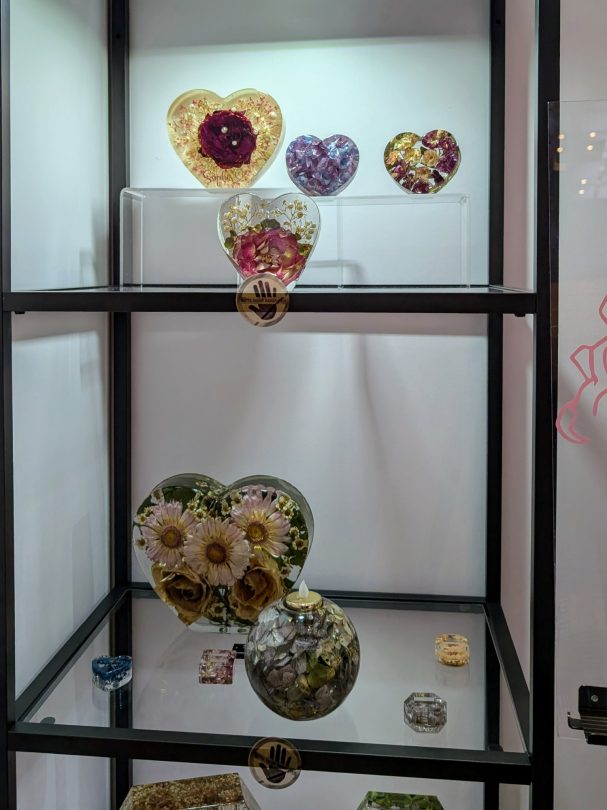 Glasherzen in verschiedenen Farben und Designs, dekoriert mit Blumen und Mustern.
